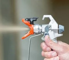AcraStrip 600 Mod Auto a spray gun shooting out a liquid with a hand pressing down on the trigger
