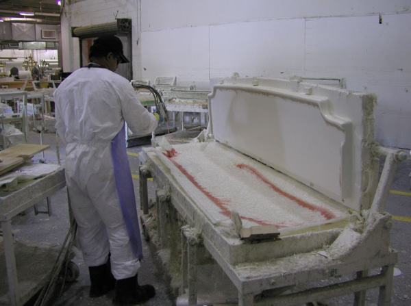 person using AcraStrip to safely clean a component in a factory
